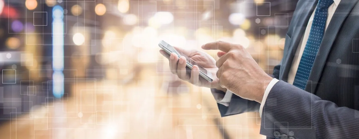 Aplicaciones empresariales cada vez más móviles Empresario en un centro de datos con un teléfono inteligente en sus manos