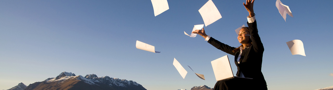 businesswoman throwing papers in air